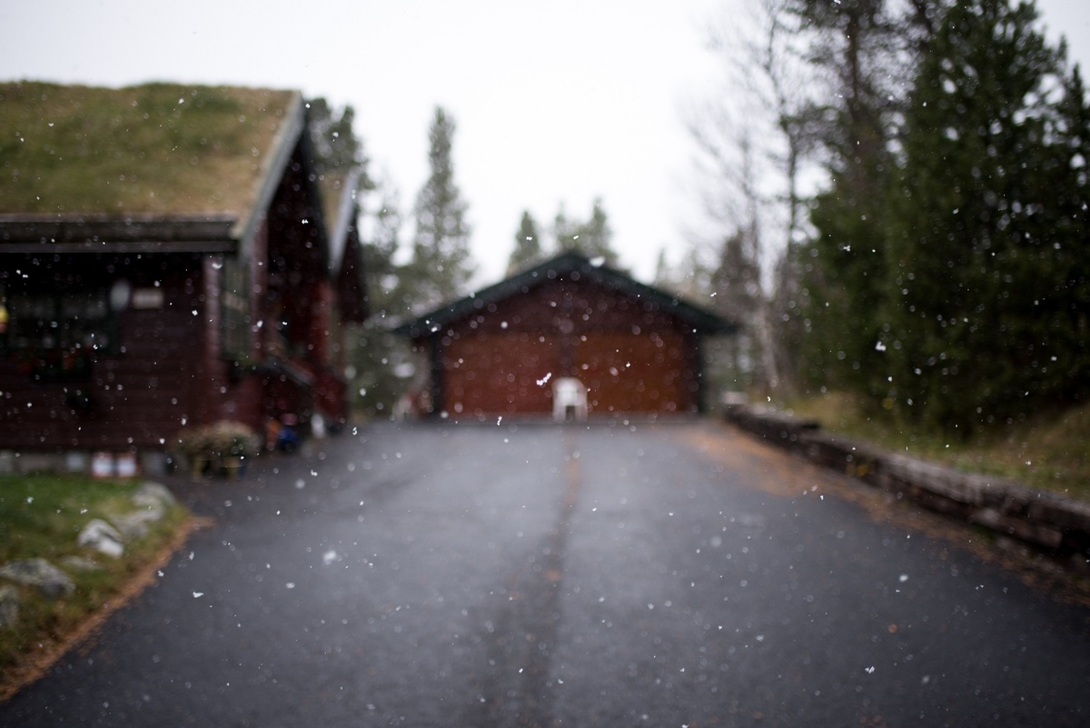 Blurred view of house and driveway during snow